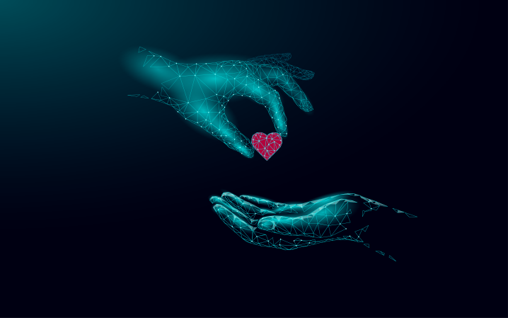 Image of one hand placing a heart in another hand