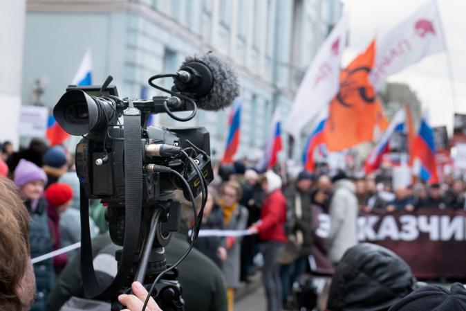 Image of videographer recording Russian protest. 